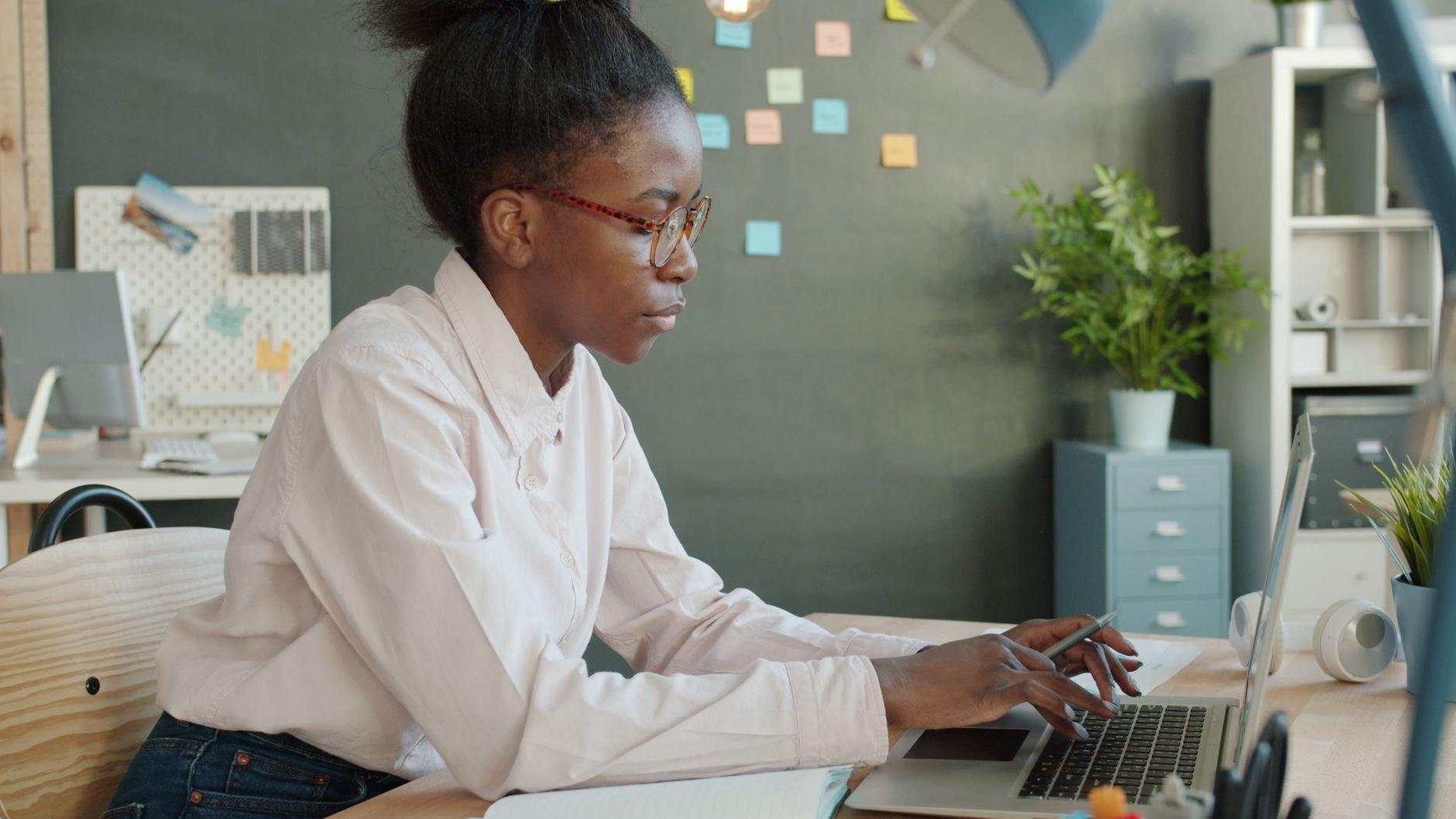 Professional focused at a laptop in a modern, well-lit workspace