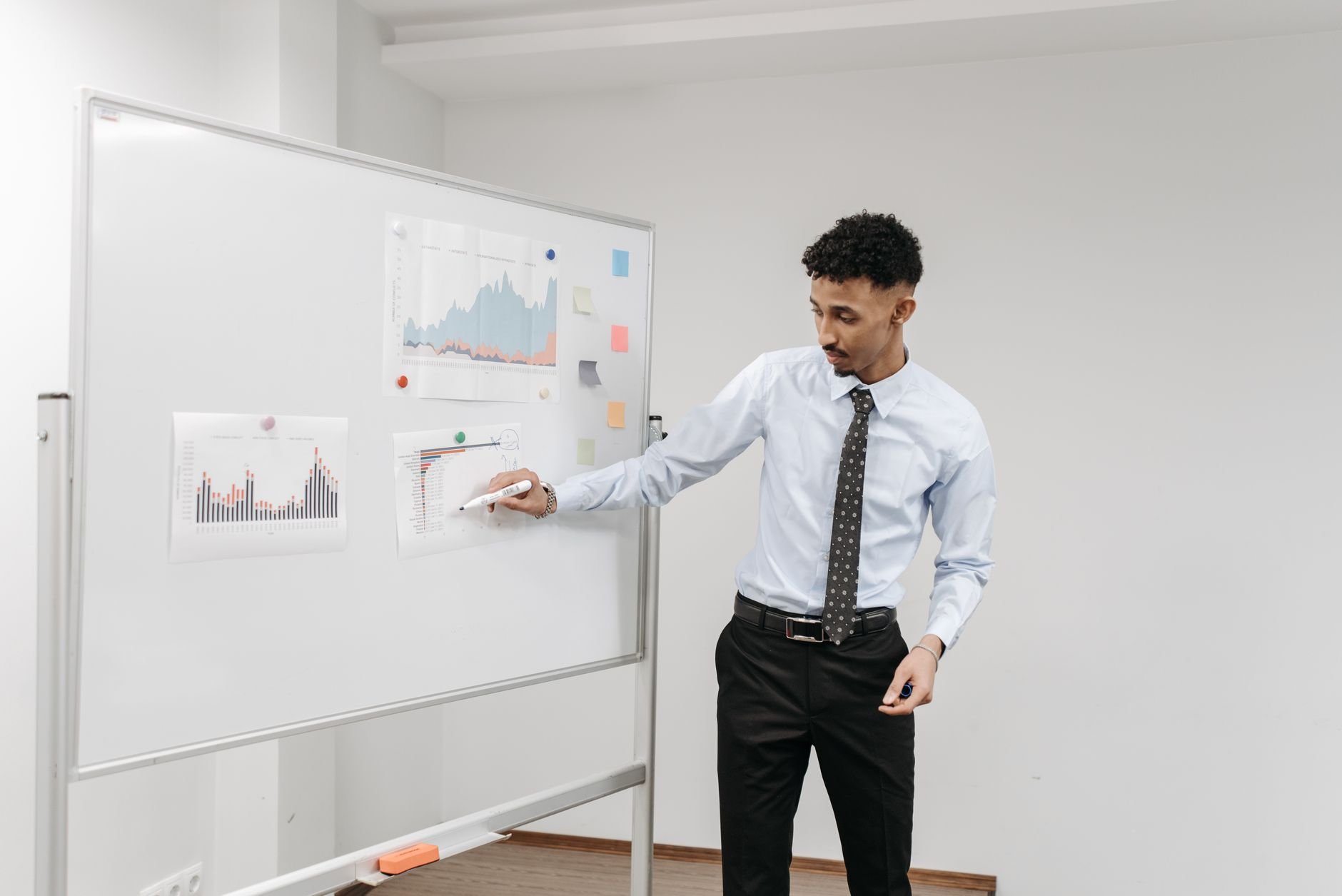 Professional presenting information on a whiteboard in a business setting