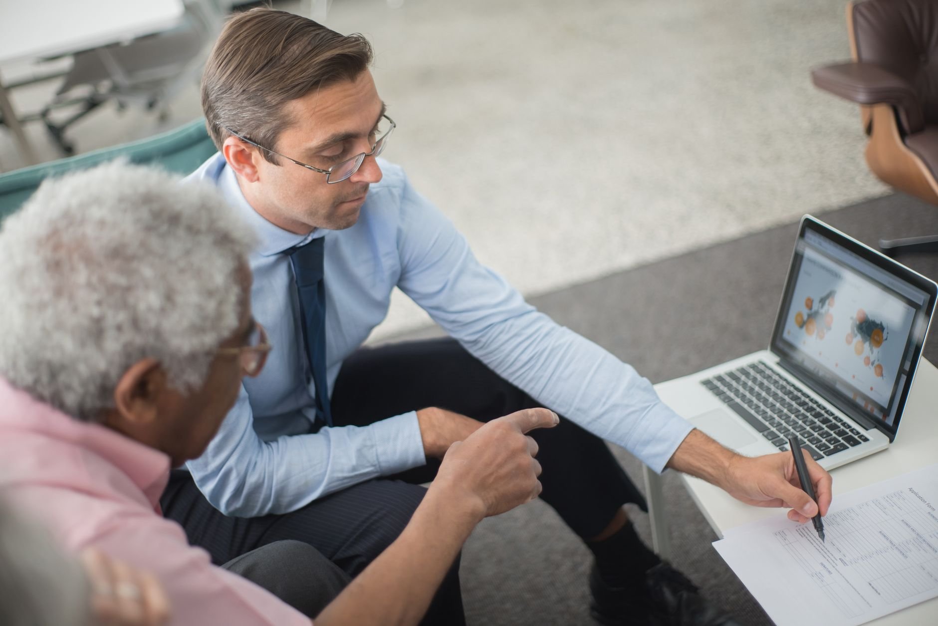 Two professionals reviewing documents together at a business meeting